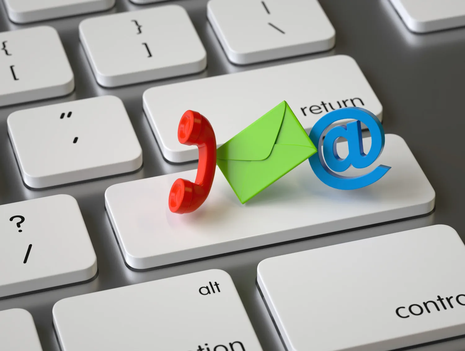 A keyboard with three-dimensional telephone, envelope and at-sign icons, representing phone and email enquiries