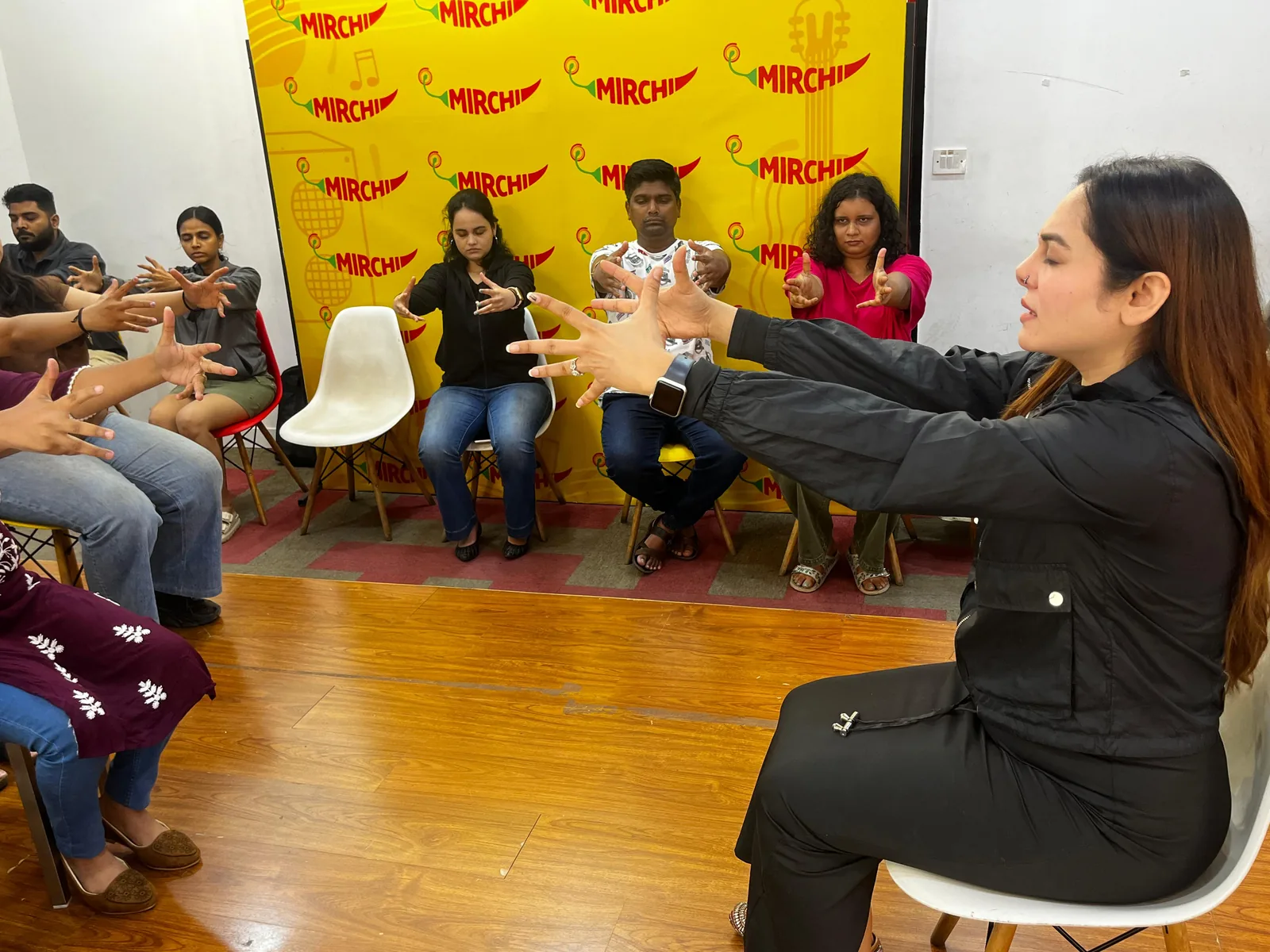 Vibha Jain seated in front of a seated audience during a group awareness session, guiding participants through a focused-attention exercise
